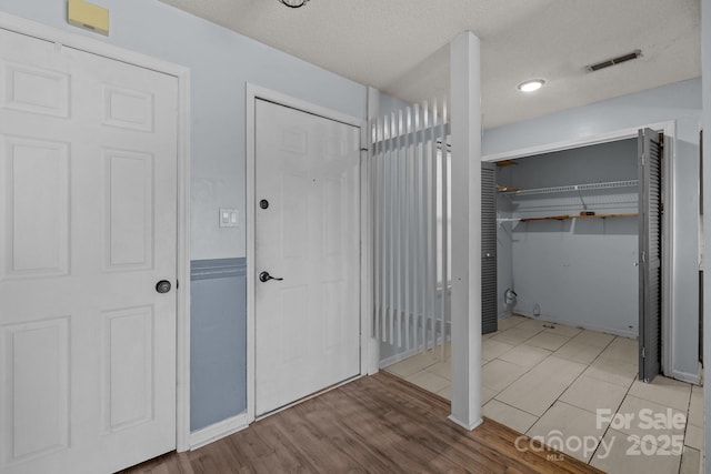 bathroom featuring tile patterned flooring and a textured ceiling