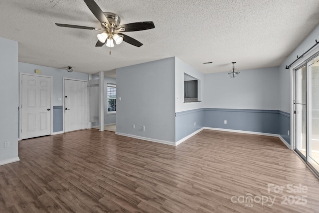 unfurnished living room featuring ceiling fan, a textured ceiling, and hardwood / wood-style flooring