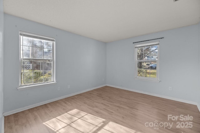 empty room featuring plenty of natural light and light hardwood / wood-style flooring