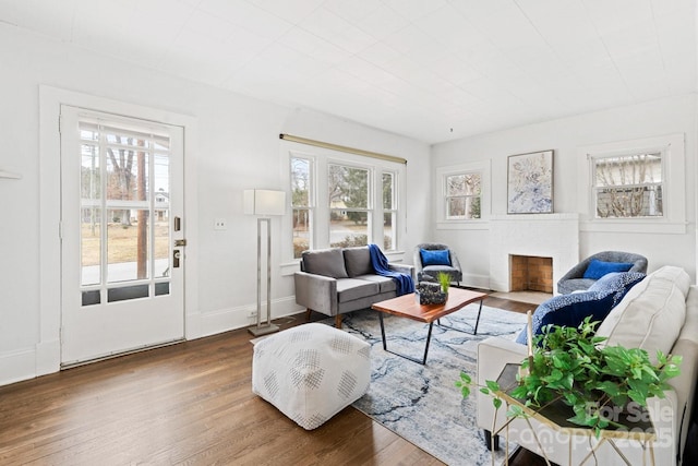 living room with hardwood / wood-style floors and a brick fireplace