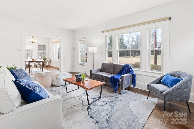 living room with an inviting chandelier and hardwood / wood-style flooring