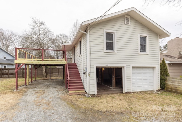 rear view of house with a garage and a deck