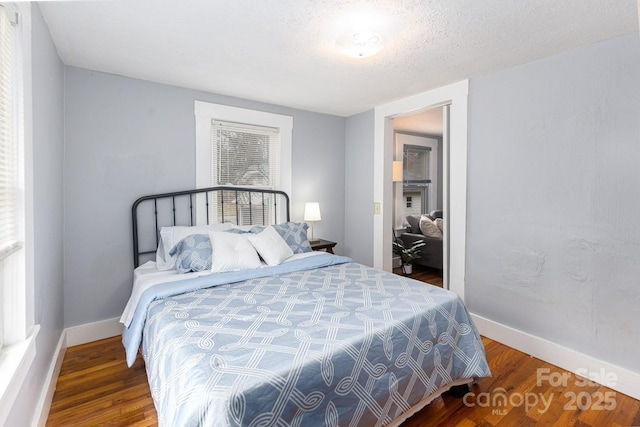 bedroom featuring dark hardwood / wood-style floors and a textured ceiling