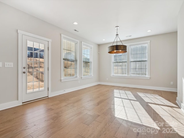 unfurnished dining area with light wood-type flooring