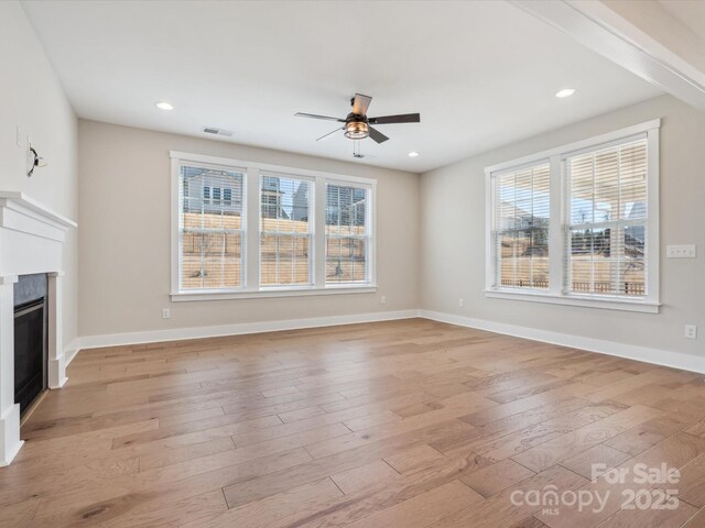 unfurnished living room with light wood-type flooring and ceiling fan