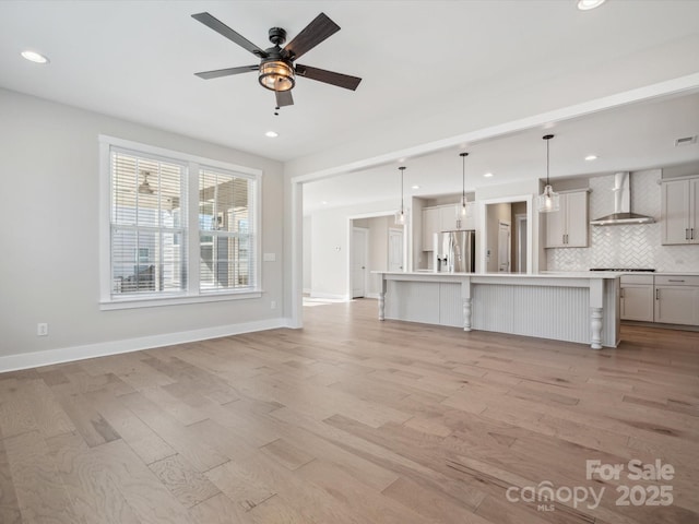 unfurnished living room with ceiling fan and light hardwood / wood-style floors