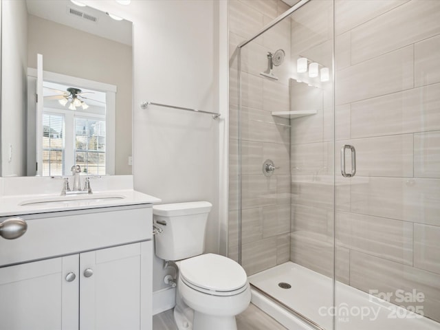 bathroom with vanity, toilet, walk in shower, and ceiling fan