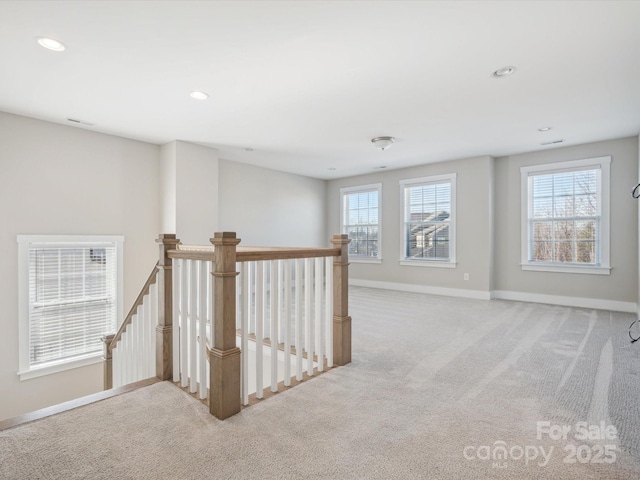 corridor with plenty of natural light and light colored carpet