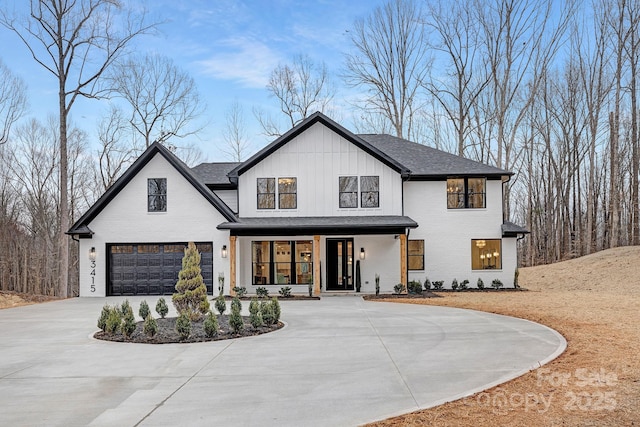 modern inspired farmhouse with brick siding, covered porch, an attached garage, board and batten siding, and driveway