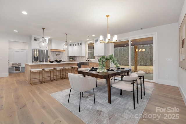 dining area featuring a chandelier, baseboards, light wood-style flooring, and recessed lighting