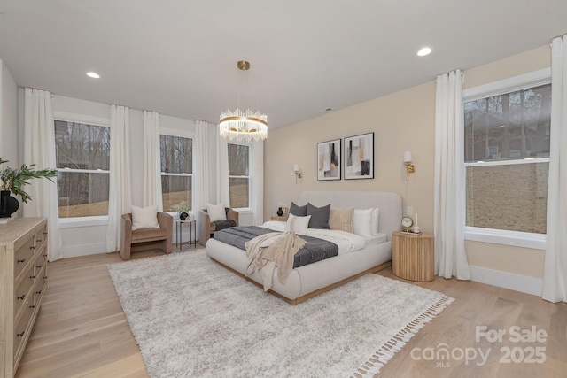 bedroom featuring light wood-style floors, recessed lighting, and a chandelier