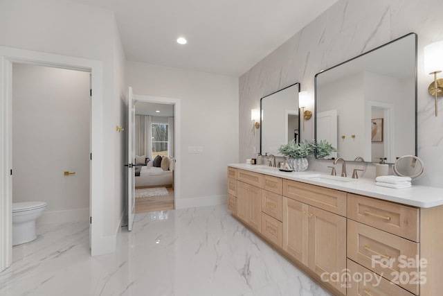 bathroom featuring double vanity, marble finish floor, ensuite bath, and a sink