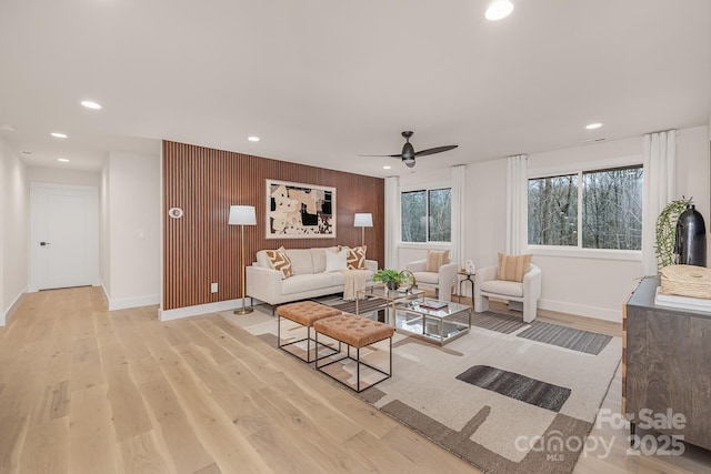 living room featuring baseboards, recessed lighting, a ceiling fan, and light wood-style floors