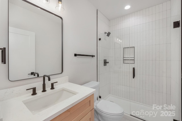 bathroom with toilet, a shower stall, recessed lighting, and vanity