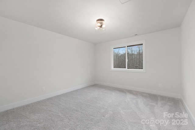 carpeted spare room featuring visible vents and baseboards