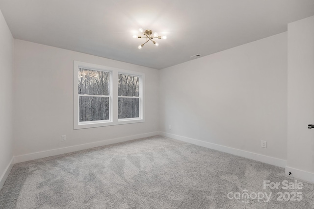 empty room featuring carpet, visible vents, and baseboards