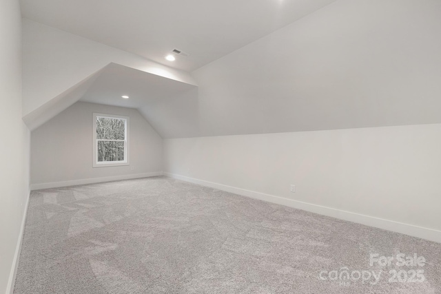 bonus room featuring lofted ceiling, carpet, visible vents, and baseboards