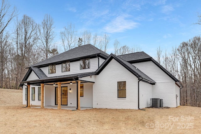 back of house with a ceiling fan, a patio, roof with shingles, central air condition unit, and brick siding