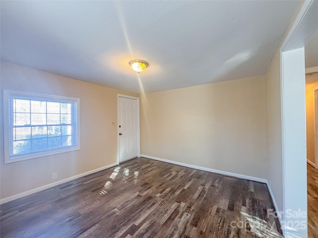 unfurnished room with dark hardwood / wood-style flooring