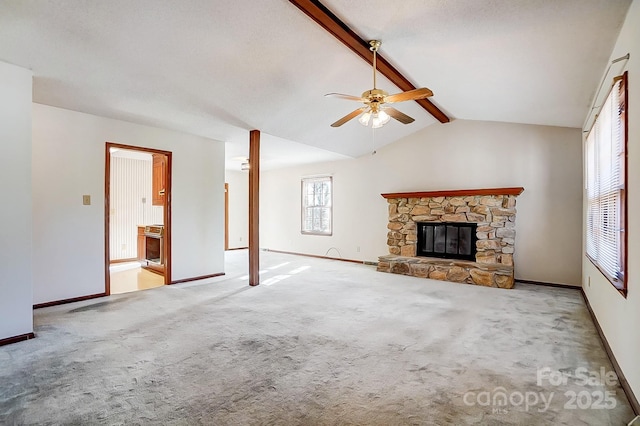 unfurnished living room with ceiling fan, light carpet, lofted ceiling with beams, and a stone fireplace