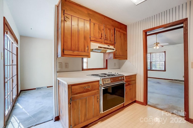 kitchen with ceiling fan, light colored carpet, and electric range