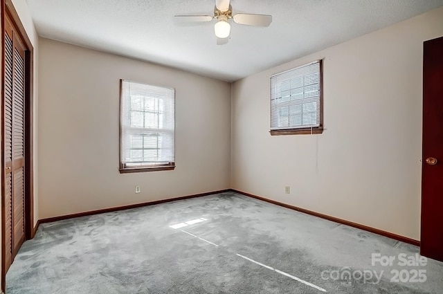 unfurnished bedroom featuring ceiling fan, a closet, and light carpet