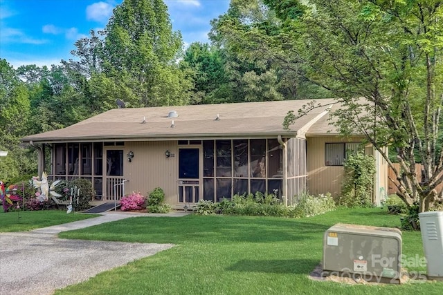 back of property featuring a sunroom and a yard