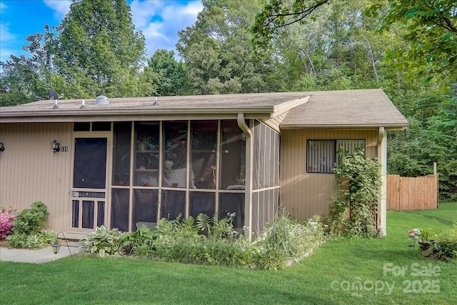 view of side of property with a lawn and a sunroom