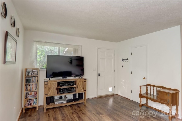 living room with dark hardwood / wood-style flooring and a textured ceiling