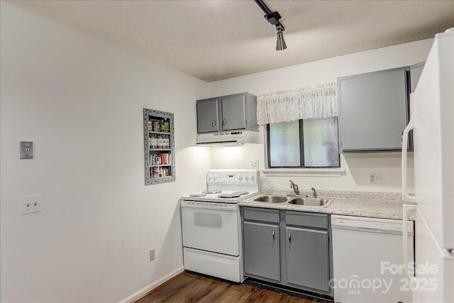 kitchen featuring dark hardwood / wood-style flooring, track lighting, white appliances, sink, and gray cabinets