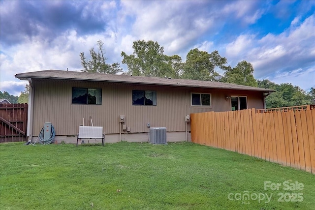 back of property featuring central AC unit and a yard