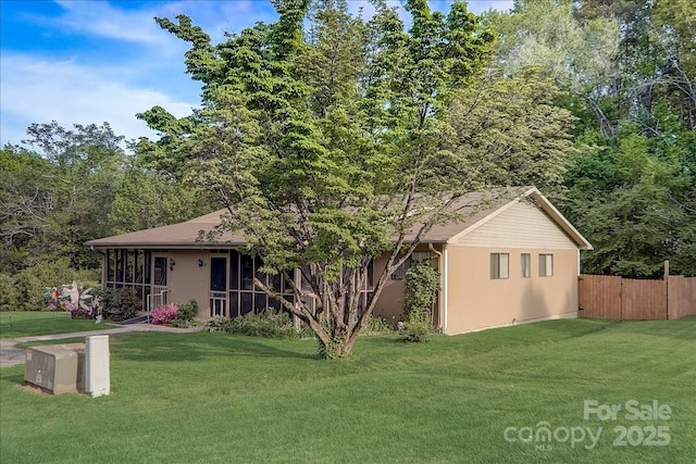 view of front of house with a sunroom and a front lawn