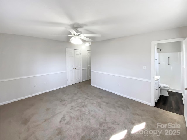 unfurnished bedroom featuring carpet flooring, ceiling fan, a closet, and ensuite bath