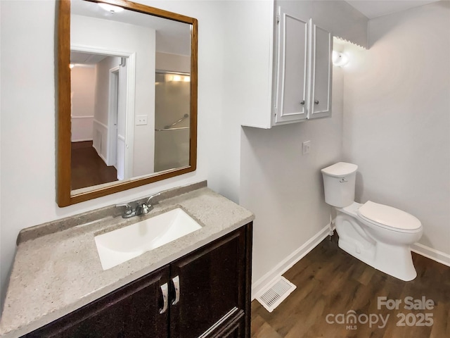 bathroom with vanity, hardwood / wood-style flooring, and toilet