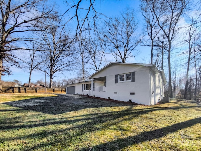 view of home's exterior with a lawn, a porch, a garage, and central AC