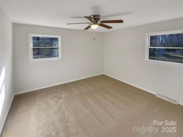 carpeted spare room with ceiling fan