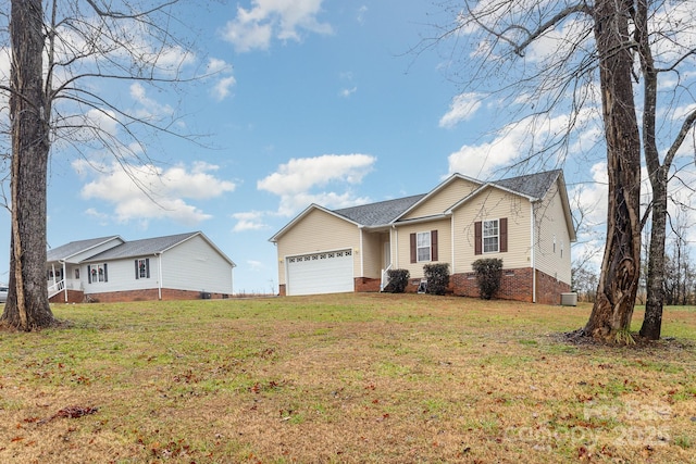 ranch-style house featuring a garage and a front lawn