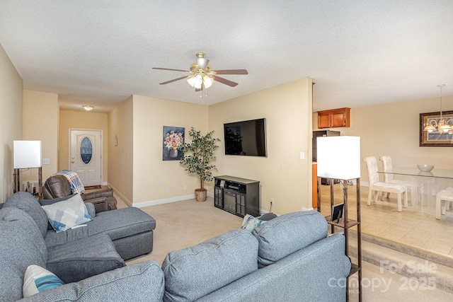 living room with ceiling fan with notable chandelier, light tile patterned floors, and a textured ceiling