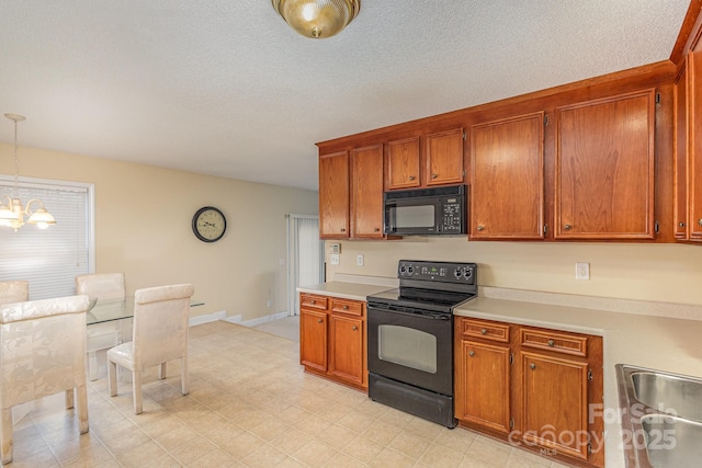 kitchen with a textured ceiling, sink, black appliances, an inviting chandelier, and hanging light fixtures