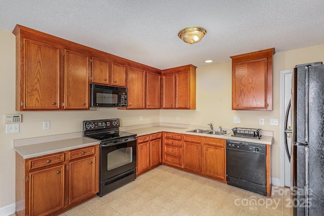 kitchen with black appliances, sink, and a textured ceiling