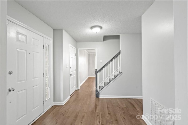 entryway featuring hardwood / wood-style floors and a textured ceiling