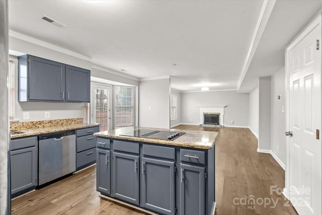 kitchen with black cooktop, ornamental molding, hardwood / wood-style flooring, dishwasher, and a kitchen island