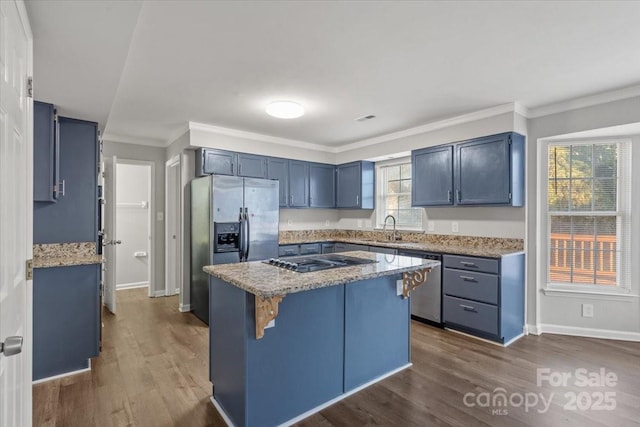 kitchen with a center island, crown molding, sink, light stone countertops, and stainless steel appliances