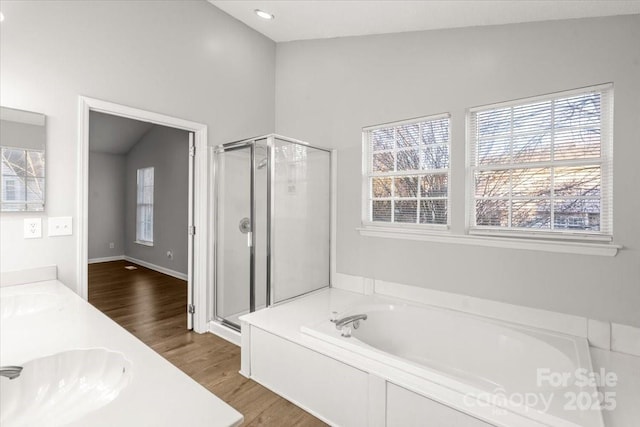 bathroom featuring vanity, independent shower and bath, vaulted ceiling, and wood-type flooring