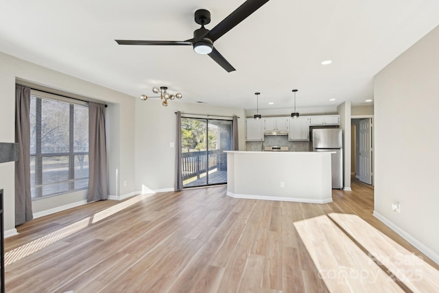 unfurnished living room with ceiling fan and light hardwood / wood-style flooring