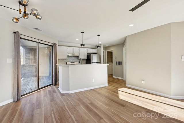 kitchen featuring light hardwood / wood-style flooring, white cabinets, tasteful backsplash, and stainless steel refrigerator