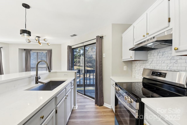 kitchen featuring backsplash, pendant lighting, sink, white cabinetry, and stainless steel electric stove