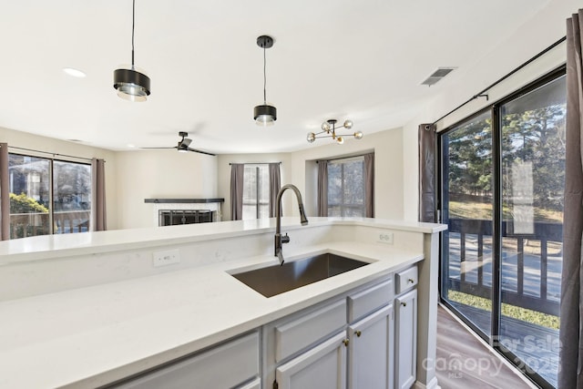 kitchen with ceiling fan, sink, plenty of natural light, and decorative light fixtures