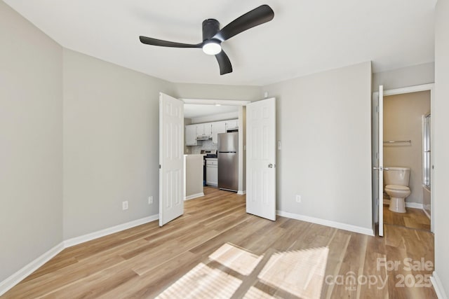 unfurnished bedroom with ensuite bath, ceiling fan, light hardwood / wood-style flooring, and stainless steel refrigerator