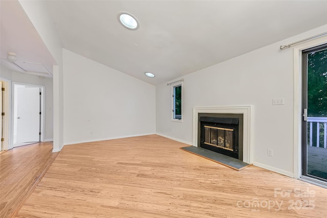 unfurnished living room with lofted ceiling and light hardwood / wood-style floors